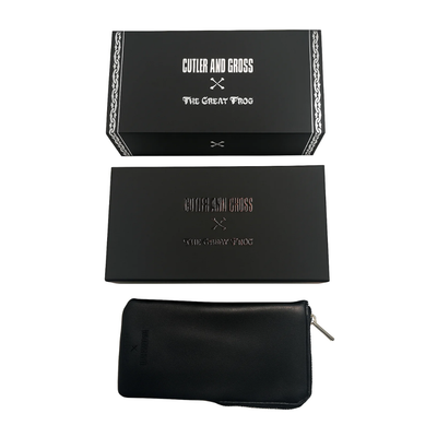 A black leather zippered pouch shown with its matching black presentation box and inner box on a plain white background. The packaging features the Cutler and Gross x The Great Frog.