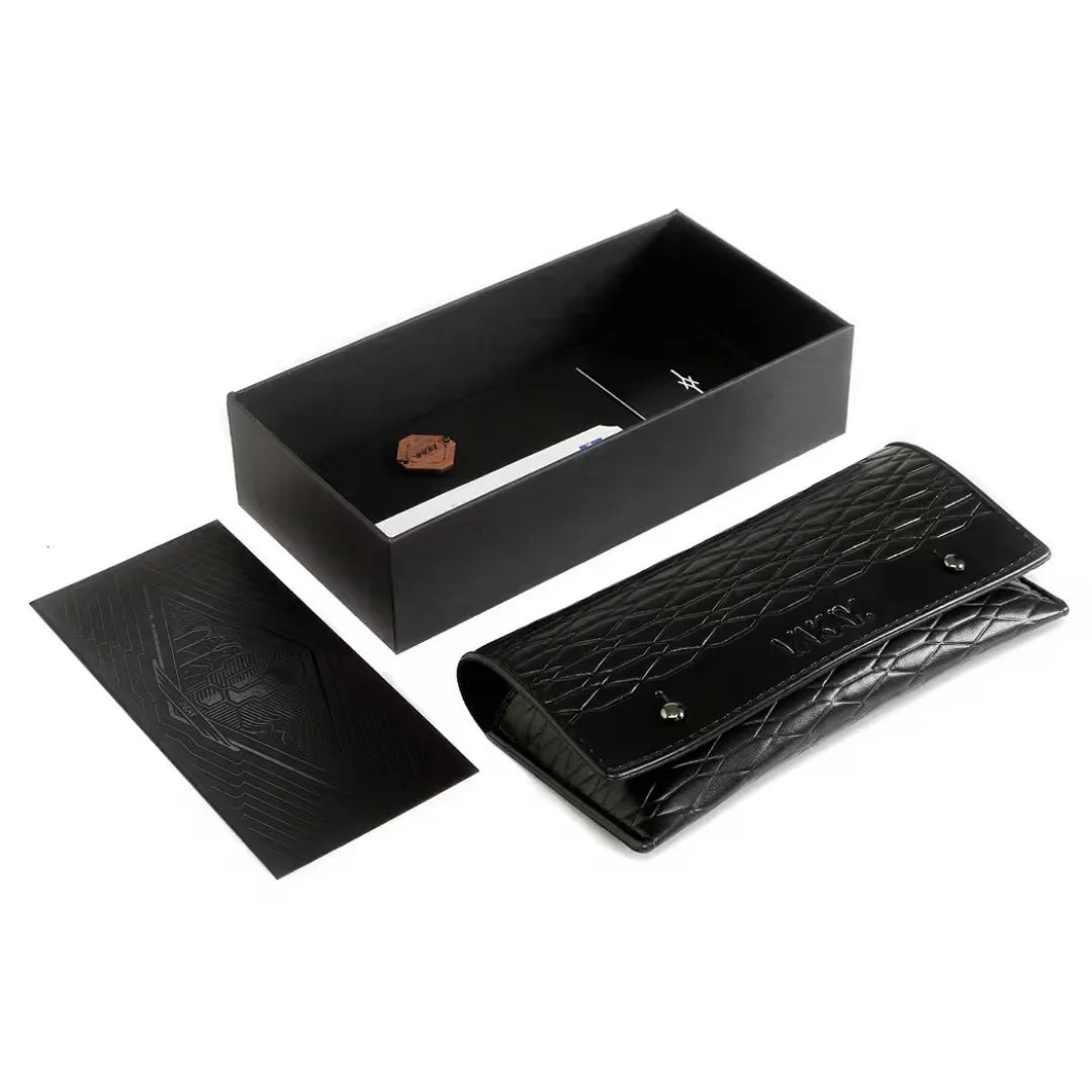 A black textured leather clutch wallet shown with its matching black presentation box, a branded black authenticity card.